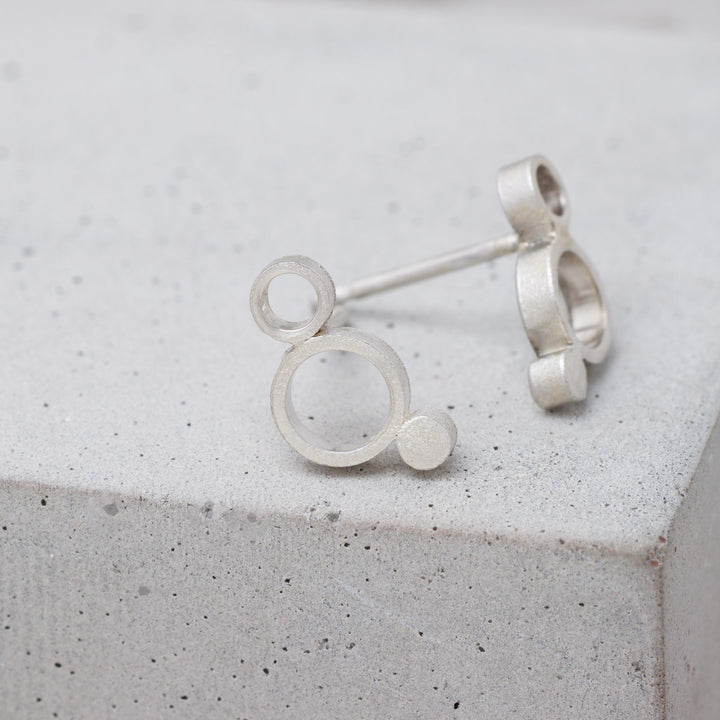 Sterling silver geometric circle stud earrings with frosted finish side
