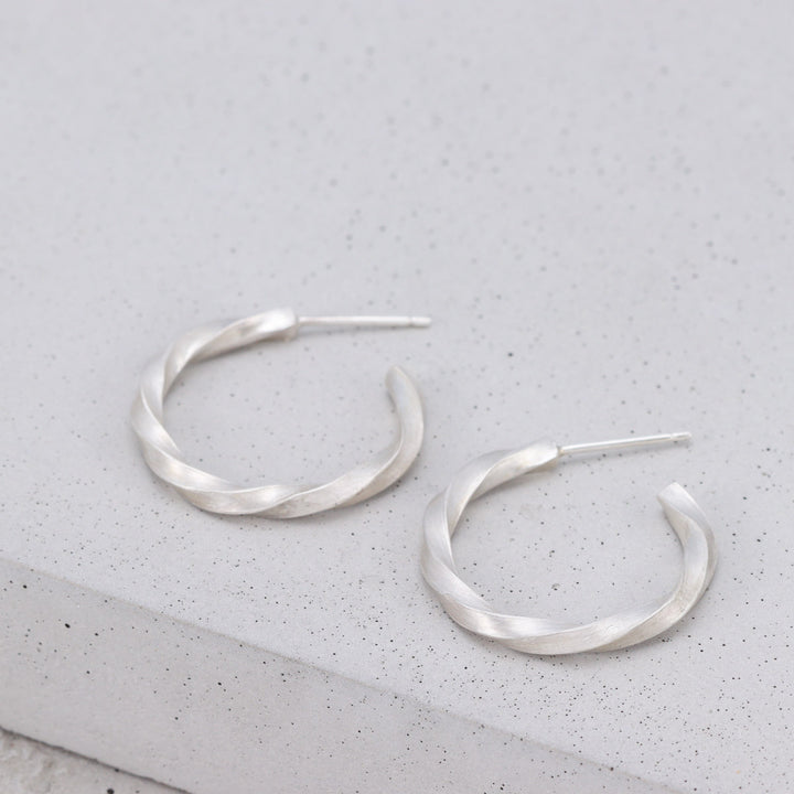 Handmade sterling silver twisted hoop earrings with brushed finish
