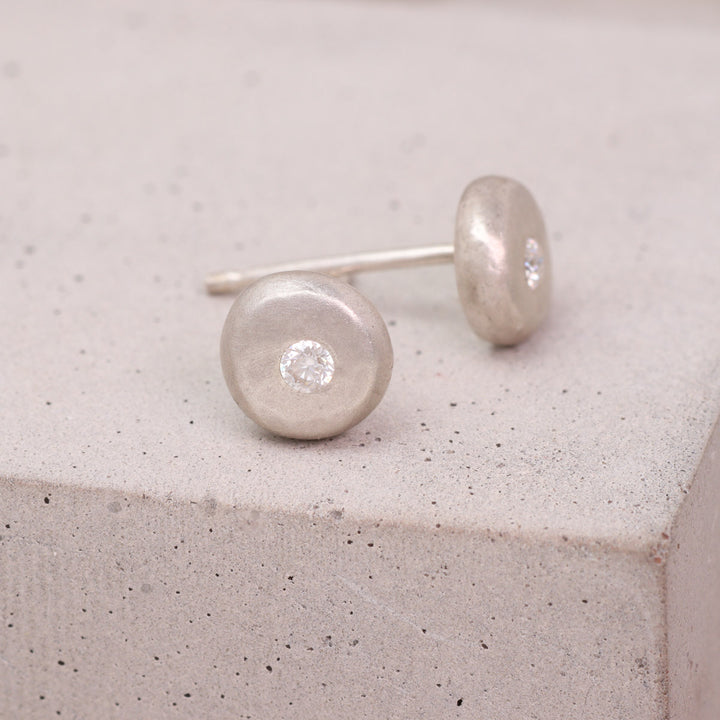 Handmade recycled silver and moissanite pebble stud earrings shown from the side