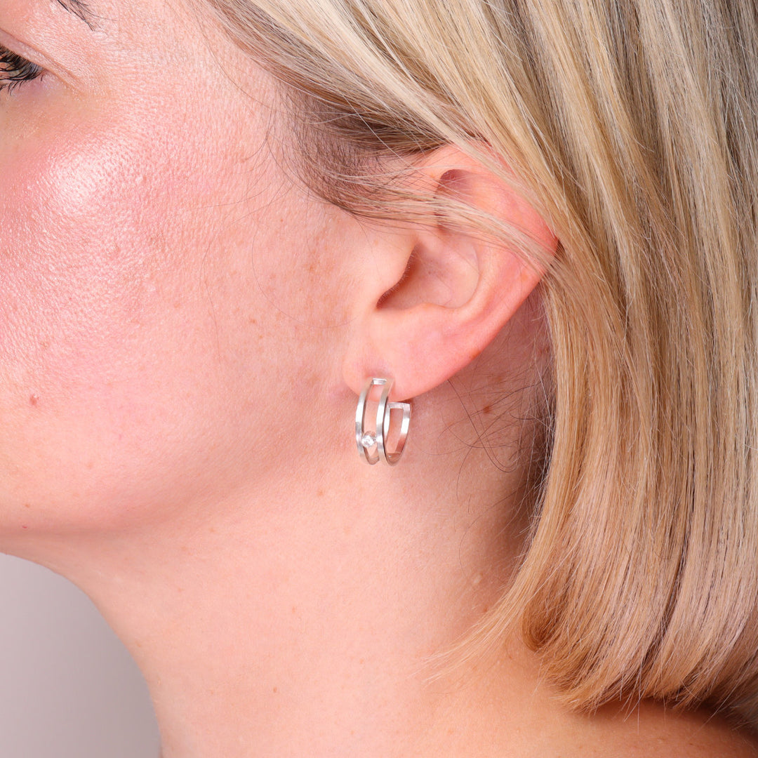 Sterling silver double hoop earrings with moissanite shown worn on the ear