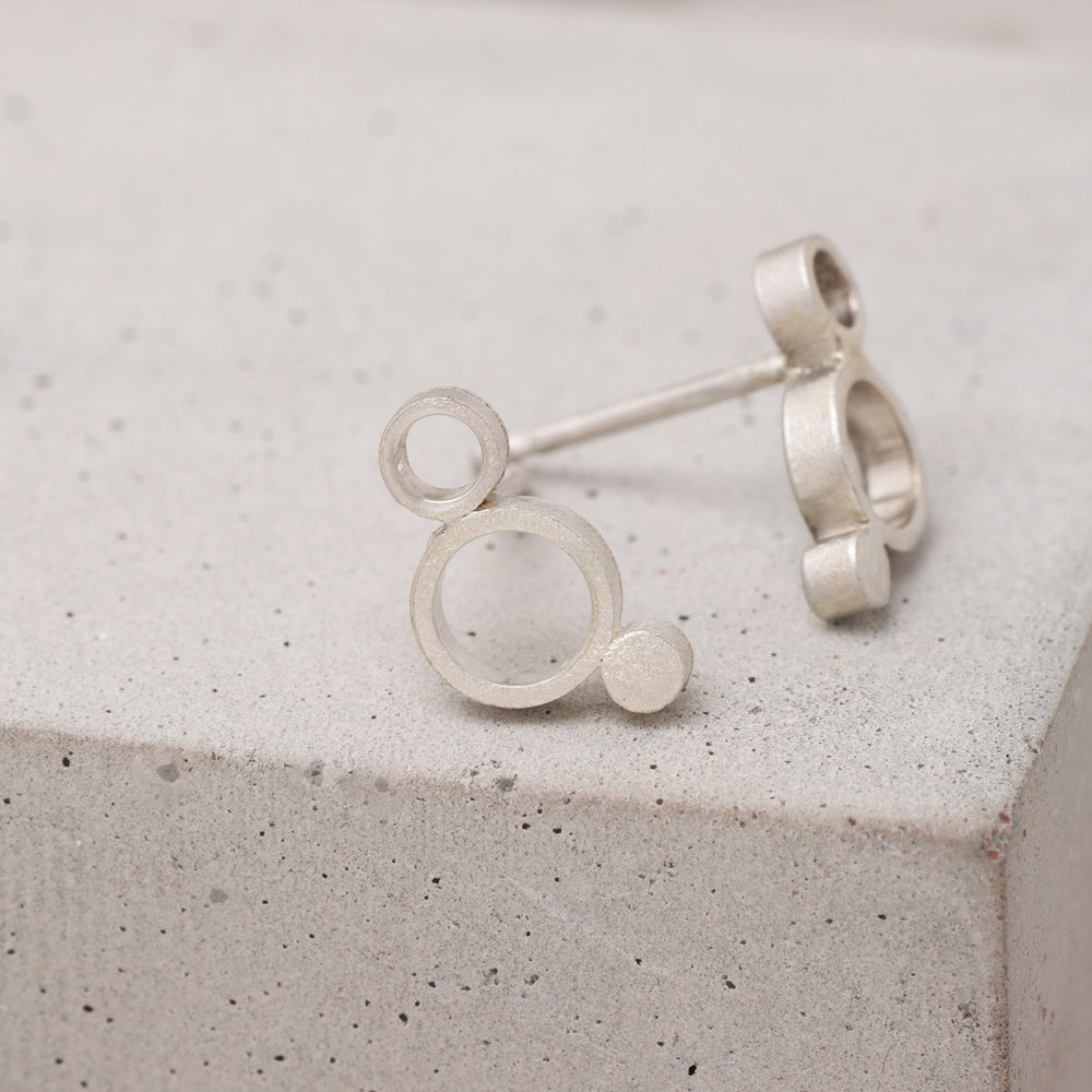 Handmade sterling silver geometric circle stud earrings shown from the side